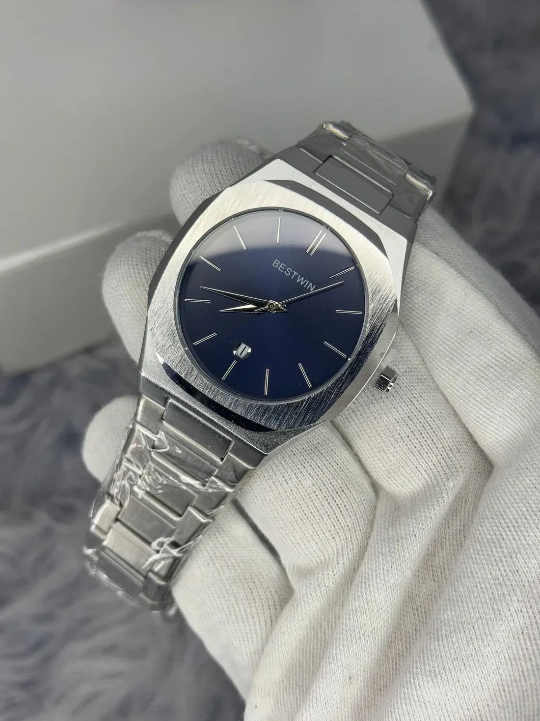 Bestwin Date Just Watch in Silver Blue with stainless steel band and blue dial held in a gloved hand