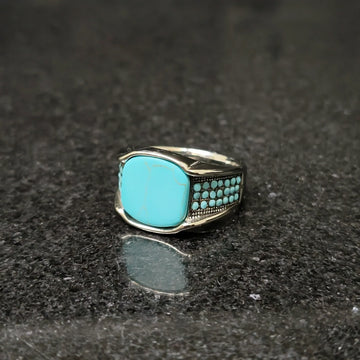 Blue feroza ring for men with silver band and turquoise stones by Lamha on black surface