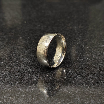 Classic silver ring for men with a smooth polished finish on a dark reflective surface