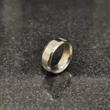 Lamha diamond ring for men in silver color with a polished faceted design on a dark surface