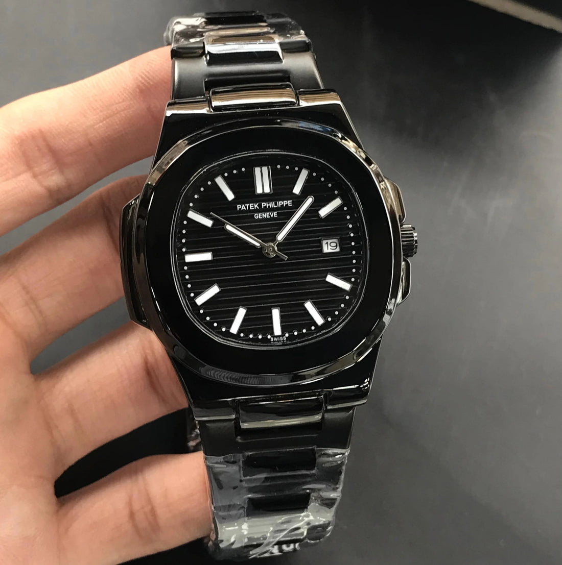 Patek Philippe In Black wristwatch with stainless steel band and black dial showing date and time
