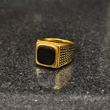 Lamha retro golden ring for men in best design with black stone and textured sides on dark surface