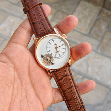 tomi t 103 dual strap watch for men with brown leather strap and white round dial held in hand
