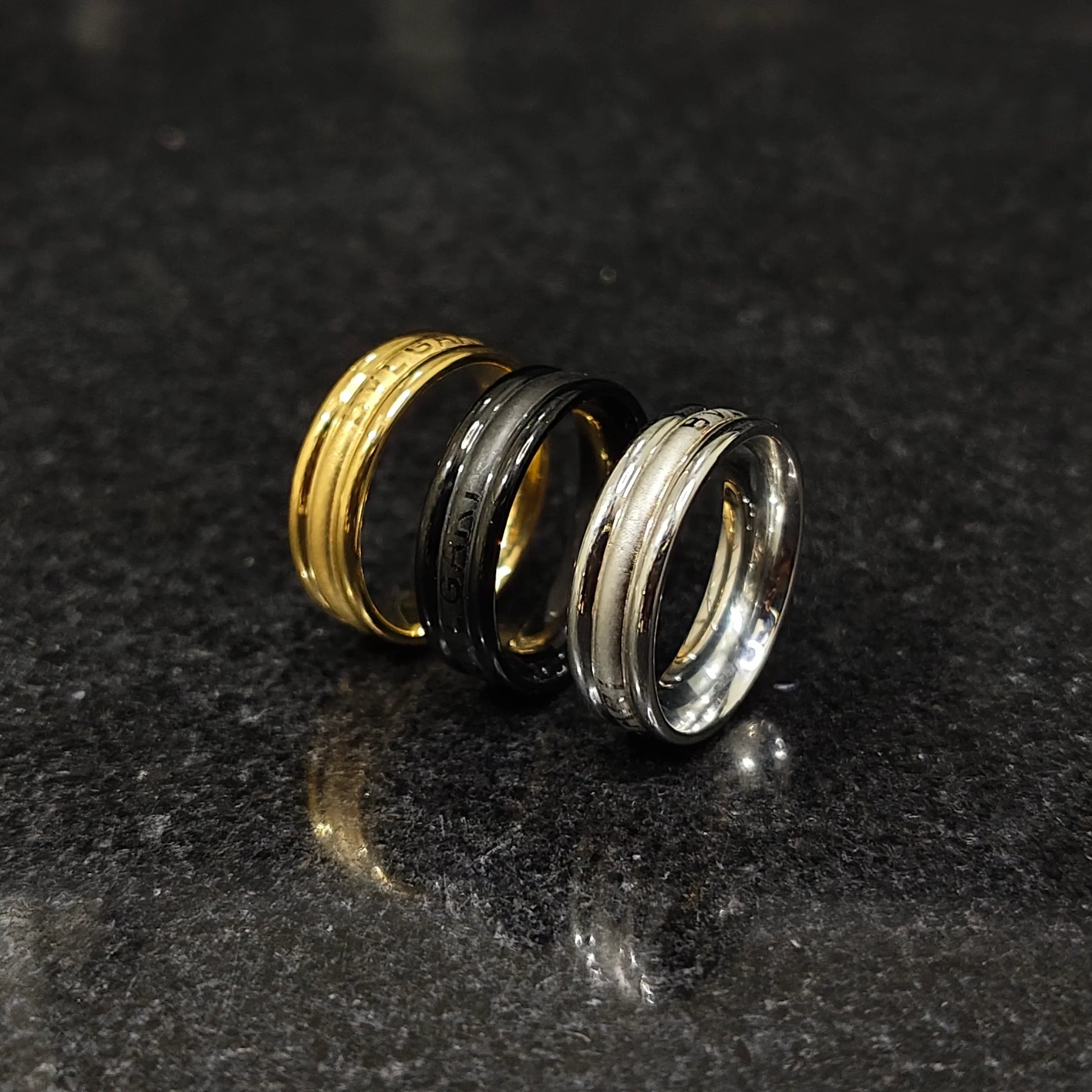 Set of 3 ferrum rings in pakistan by Lamha featuring gold, black, and silver tones on a dark surface
