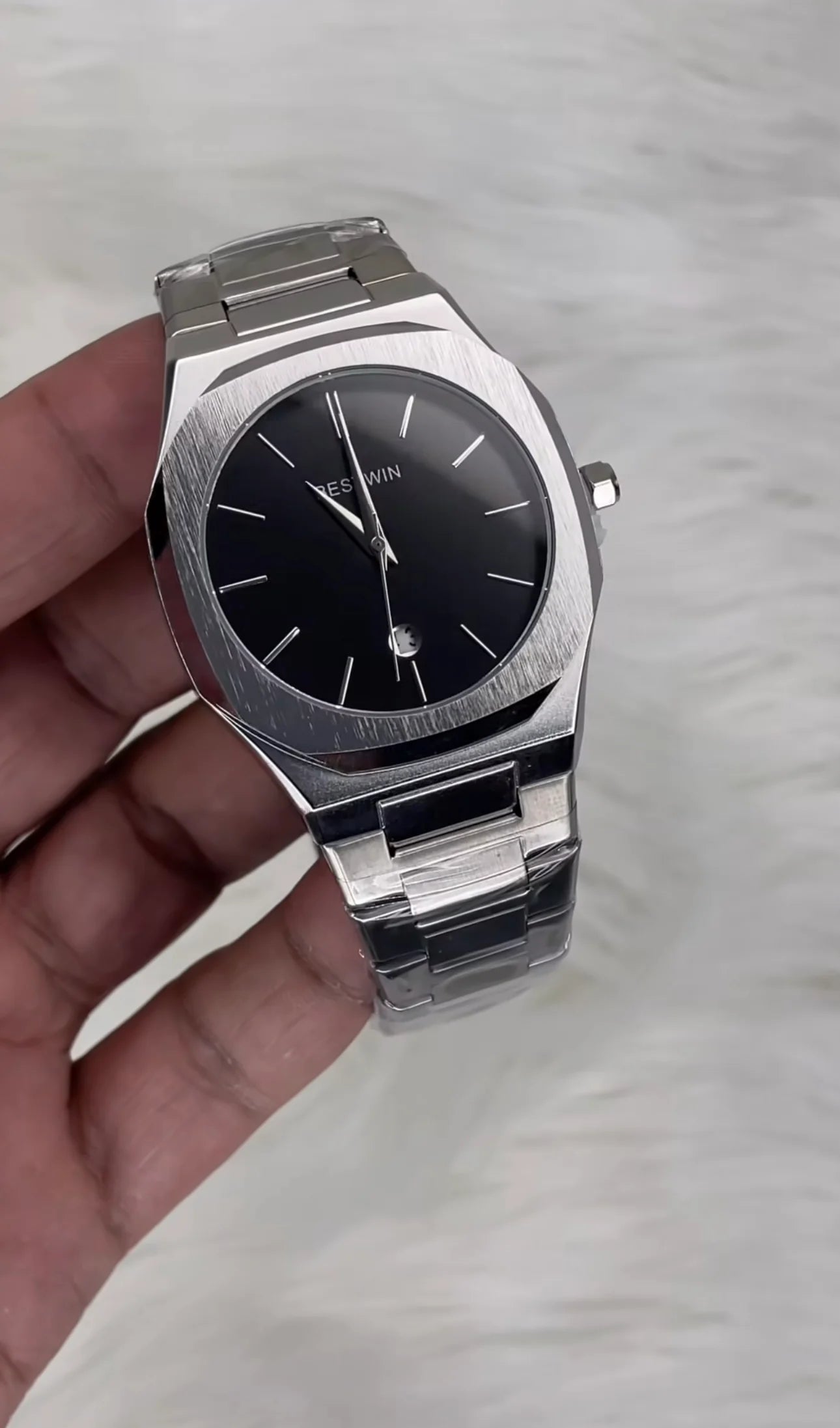 Bestwin Date Just Watch in Silver Black with stainless steel band and black dial held in hand