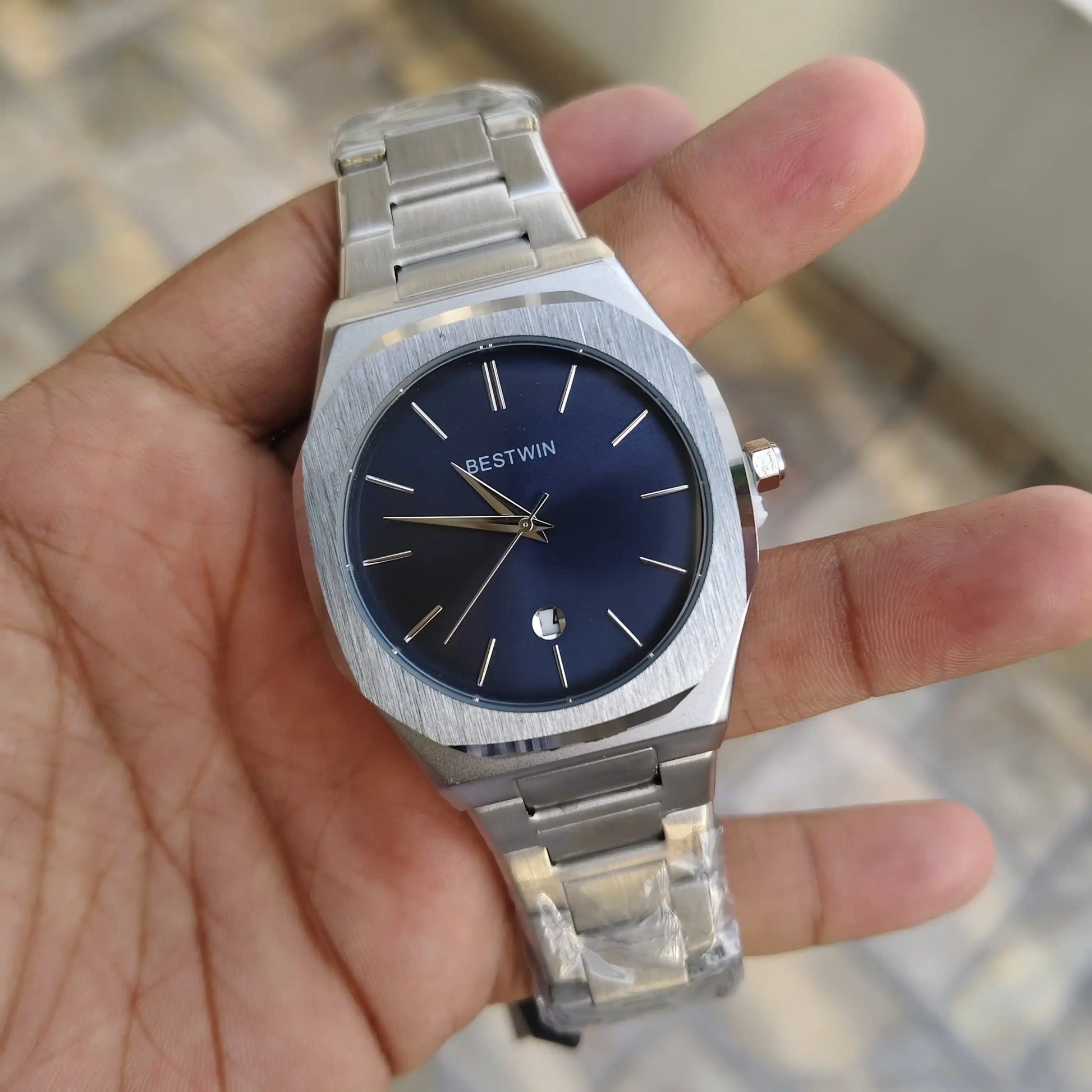 Bestwin Date Just Watch in Silver Blue with stainless steel band held in hand showing detailed dial