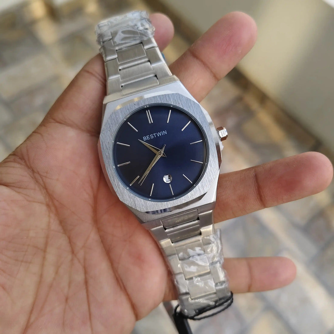 Bestwin Date Just Watch in Silver Blue with stainless steel band and blue dial held in a gloved hand