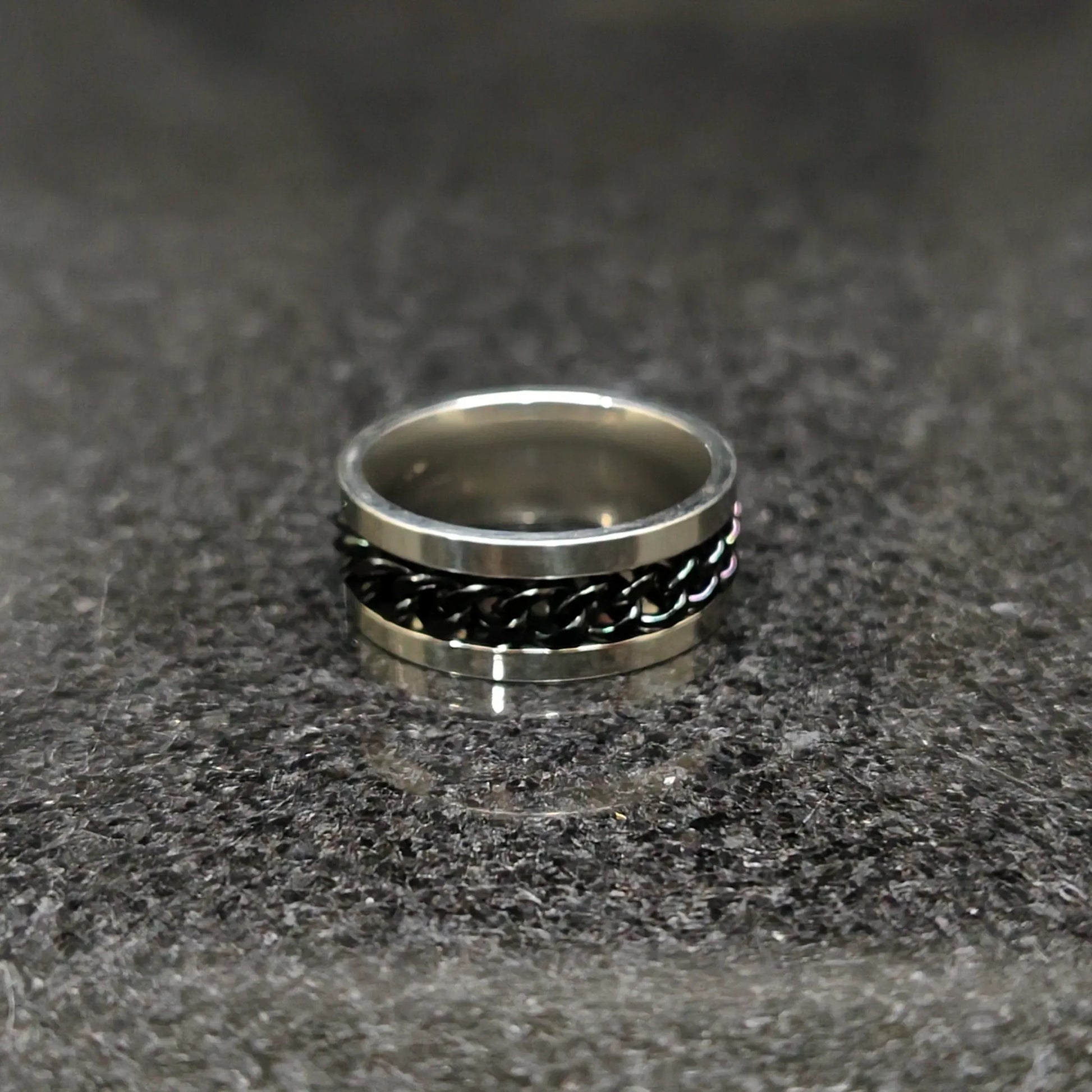 Black Curb Chain ring for men in pakistan by Lamha with silver edges on a dark textured surface