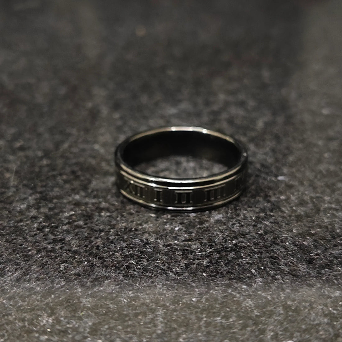 Black roman ring in best design engraved with Roman numerals on a dark textured surface