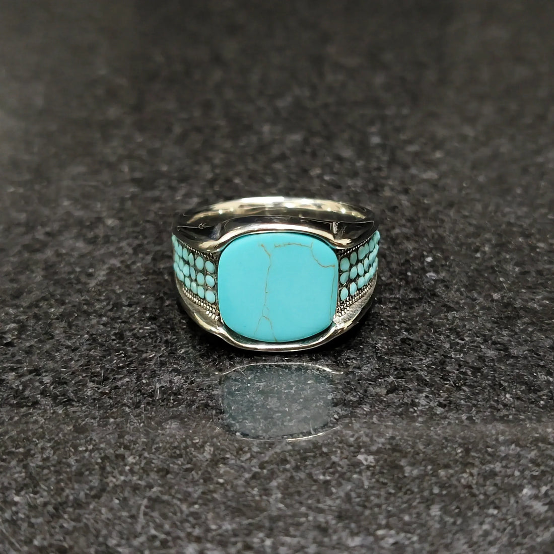Blue feroza ring for men with silver band and turquoise stones by Lamha on black surface
