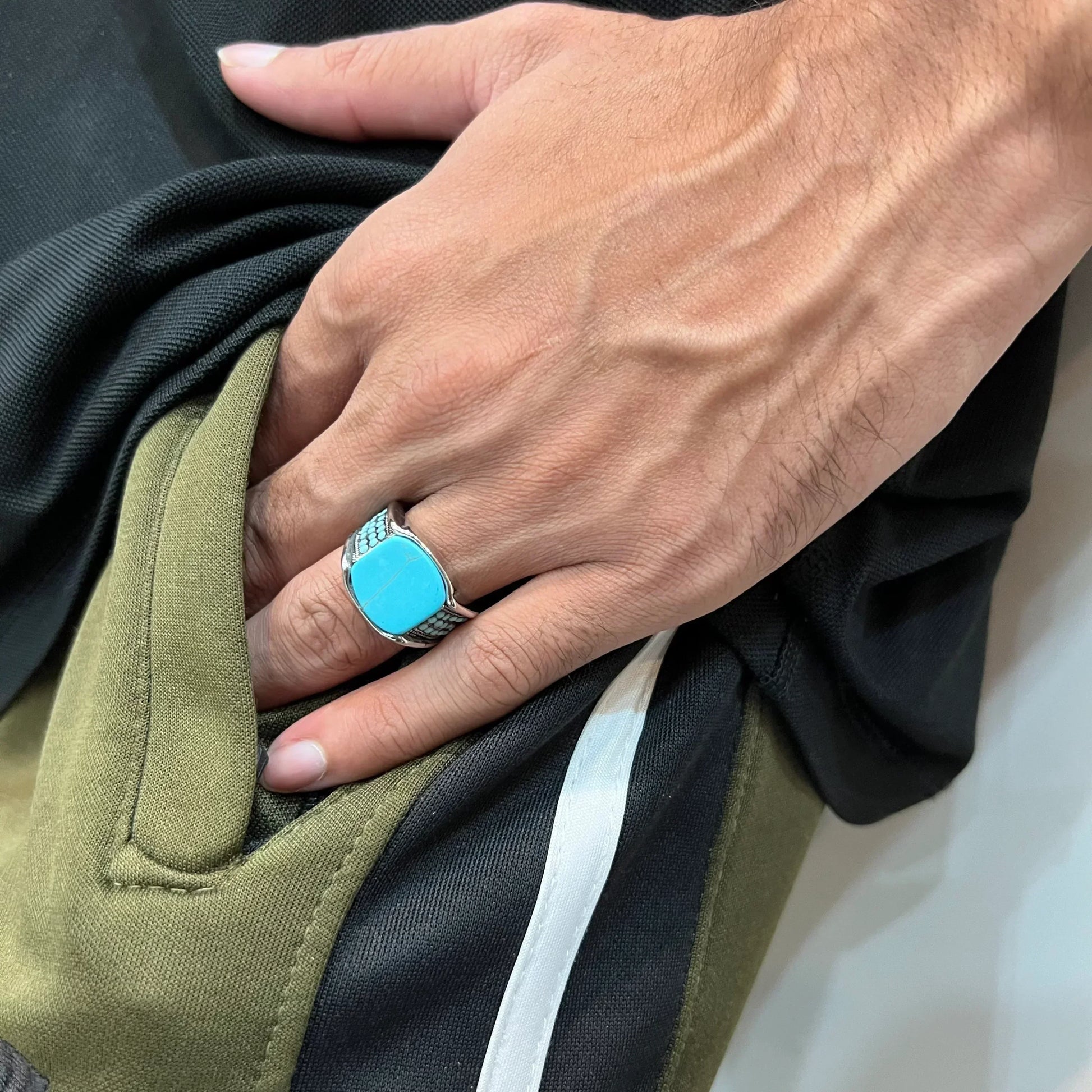 Blue feroza ring for men with silver band worn on hand over green and black clothing