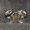 Lamha buy 3 curb chain ring in pakistan with silver, black, and gold chain design on a gray surface