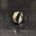 Classic silver ring for men with a smooth polished finish on a dark reflective surface