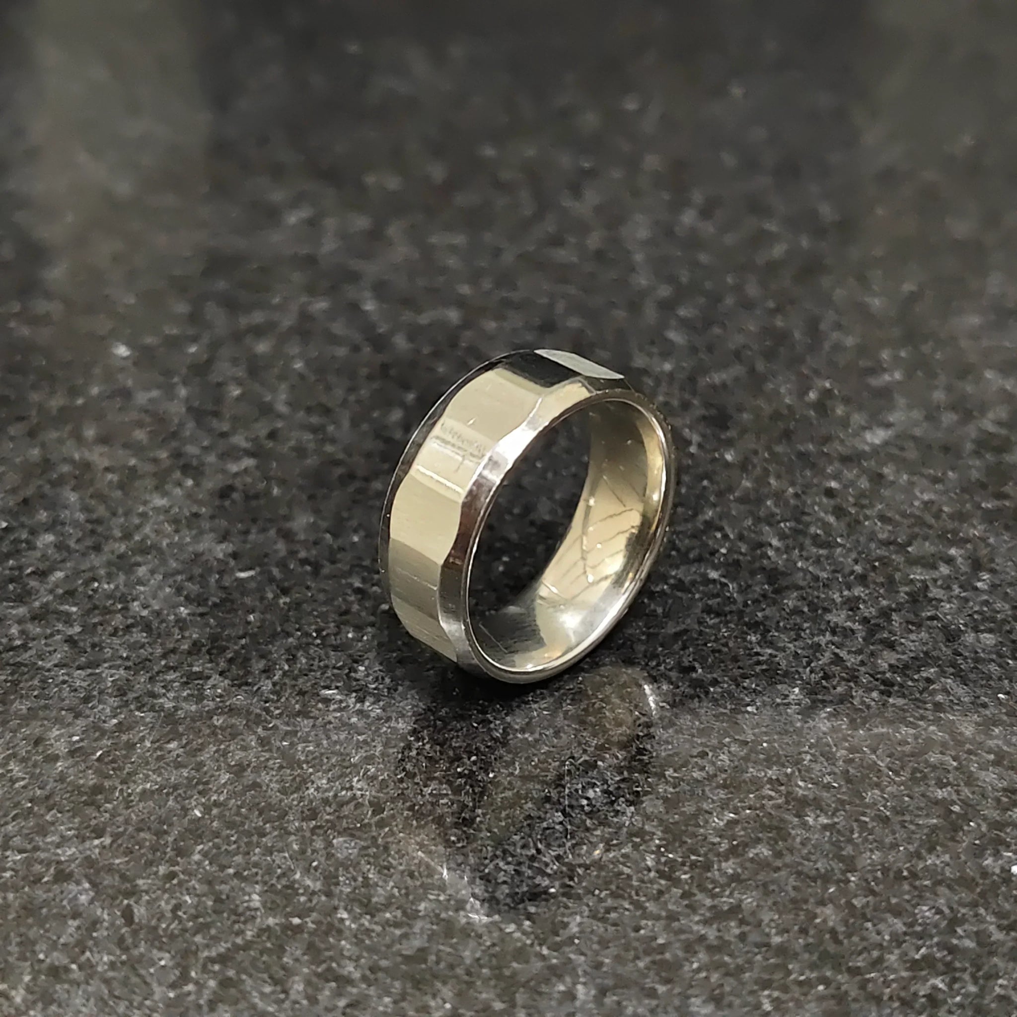 Lamha diamond ring for men in silver color with a polished faceted design on a dark surface
