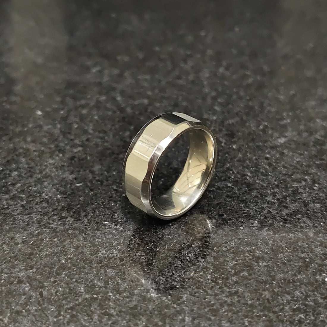 Lamha diamond ring for men in silver color with a polished faceted design on a dark surface