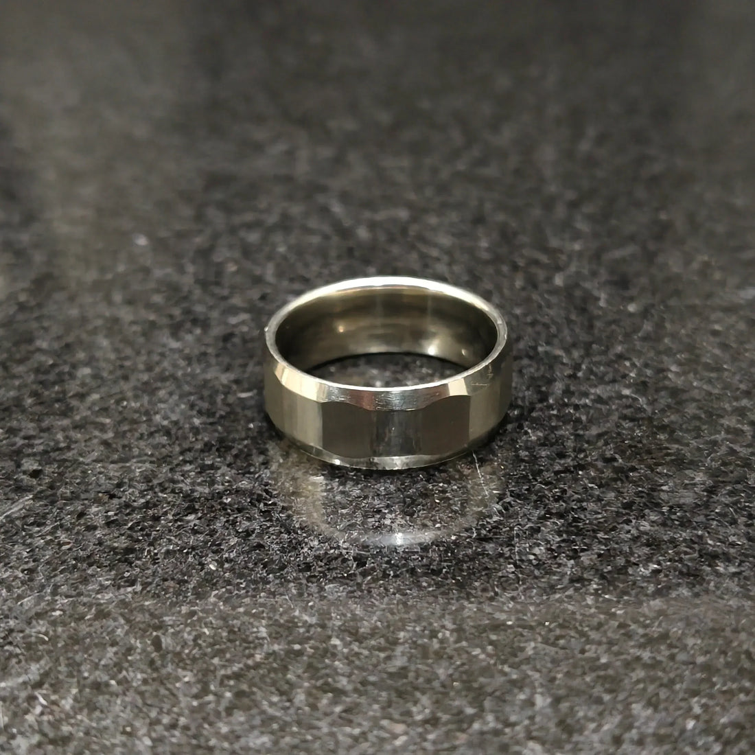 Lamha diamond ring for men in silver color with a polished faceted design on a dark surface