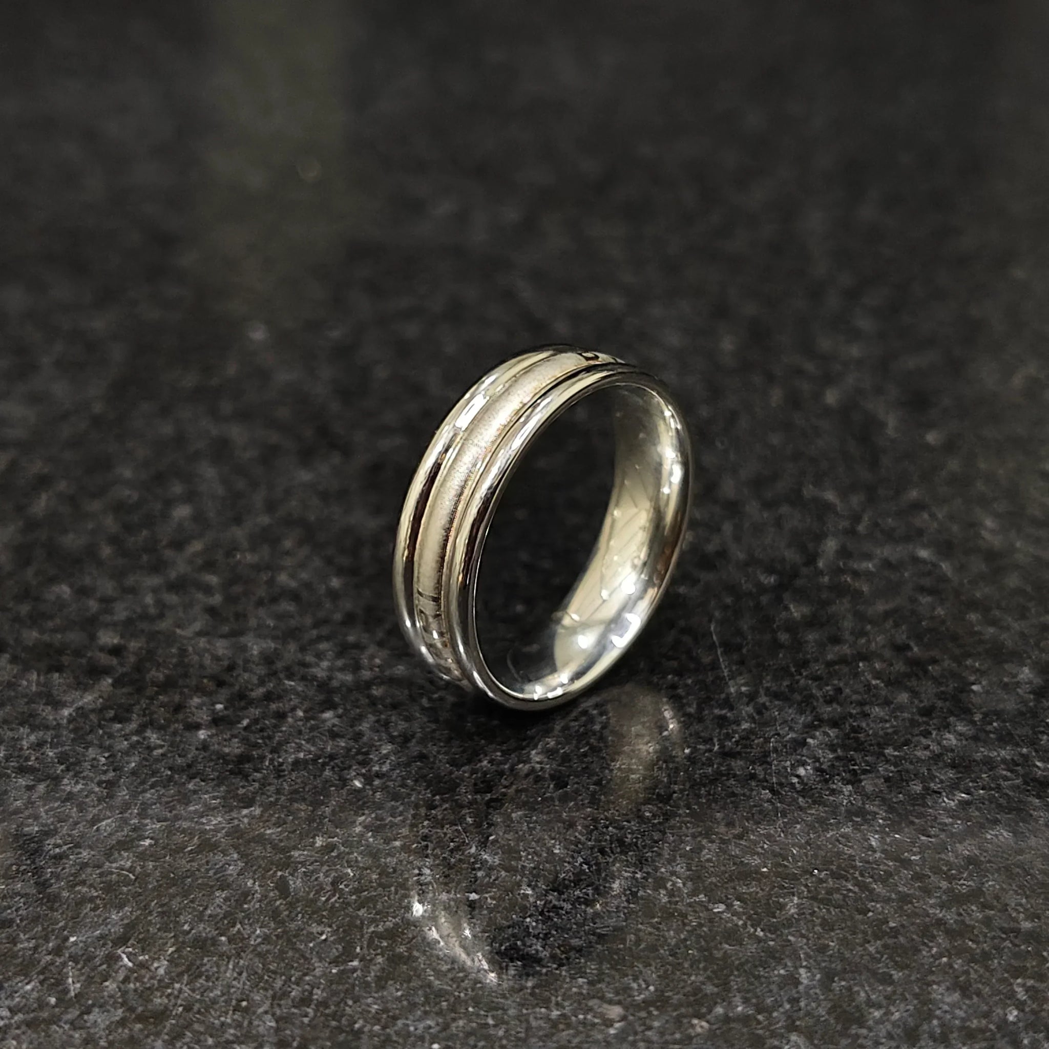Ferrum ring for men in silver color in pakistan with textured design by Lamha on black surface