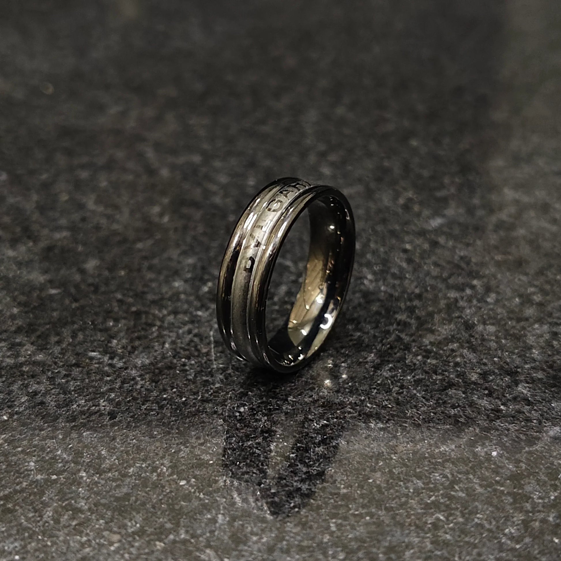 Ferrum ring in black color in pakistan with sleek metallic finish and modern design on dark surface