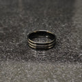Lamha Ferrum ring in black color in pakistan with sleek metallic finish on gray surface