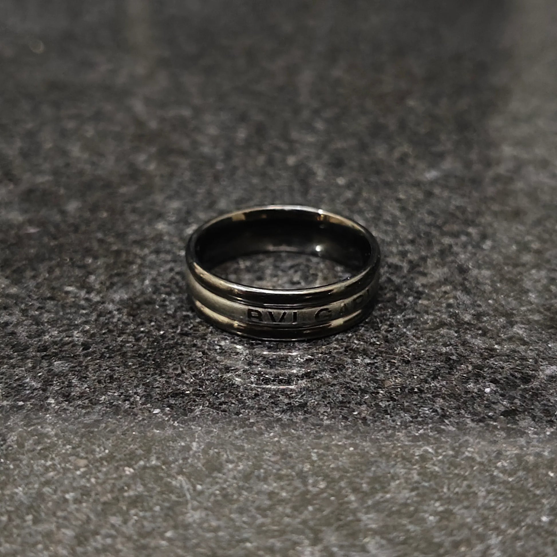 Lamha Ferrum ring in black color in pakistan with sleek metallic finish on gray surface
