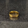 Golden ferrum ring in golden color in pakistan by Lamha with engraved design on dark surface