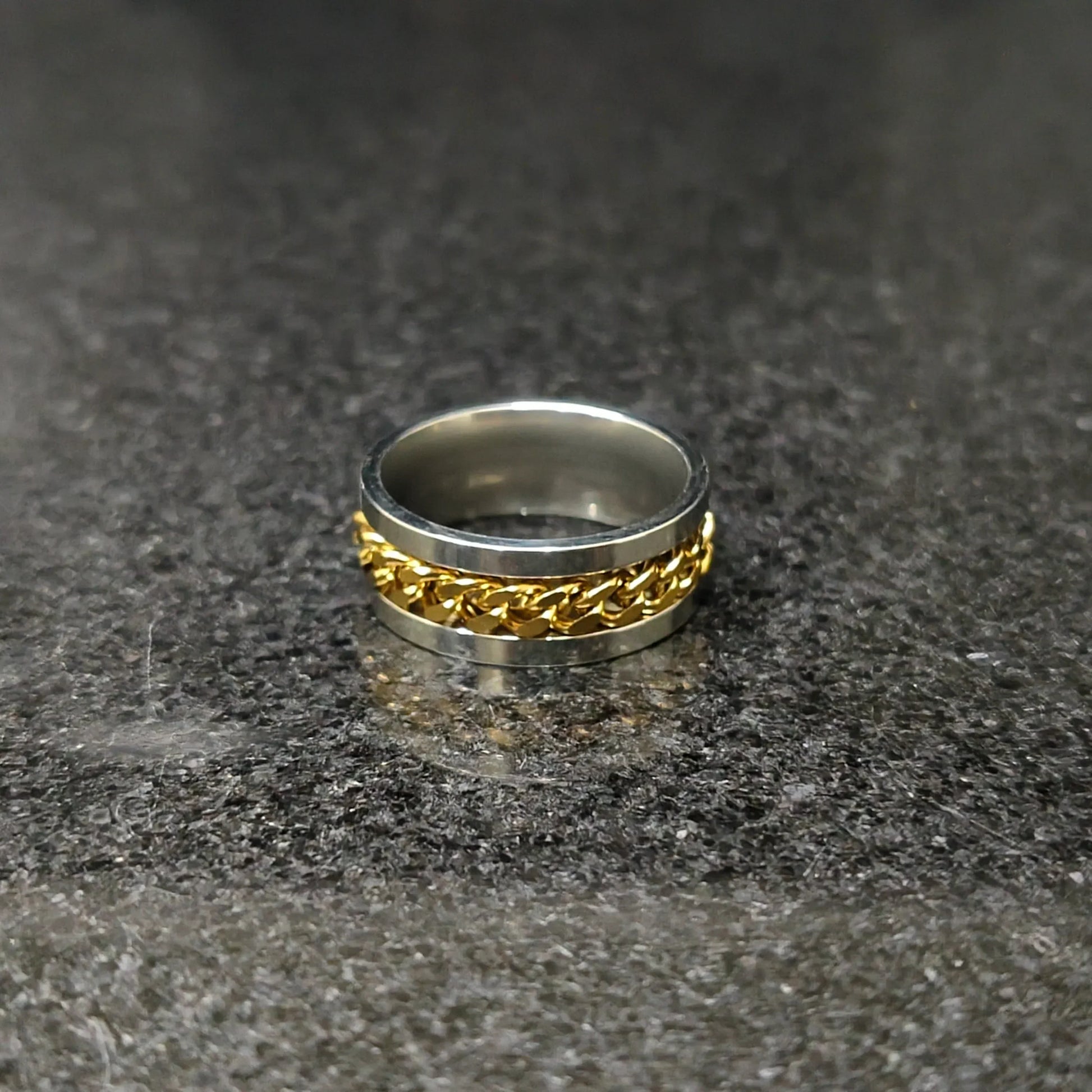 Golden curb chain ring for men in Pakistan with silver base on reflective surface