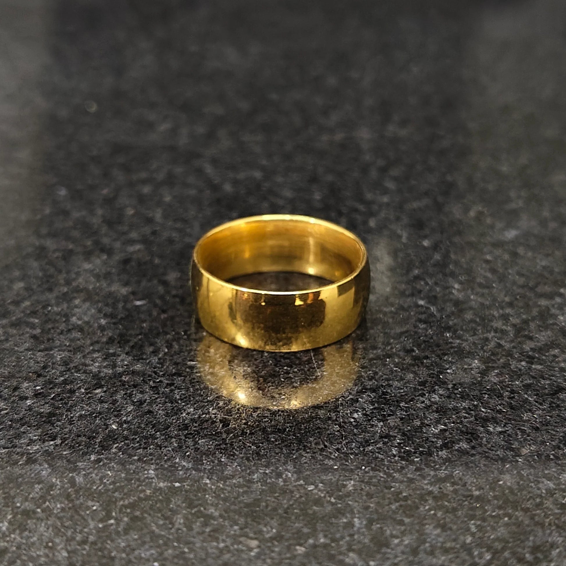 Simple polished golden ring for men in pakistan on dark granite surface by Lamha