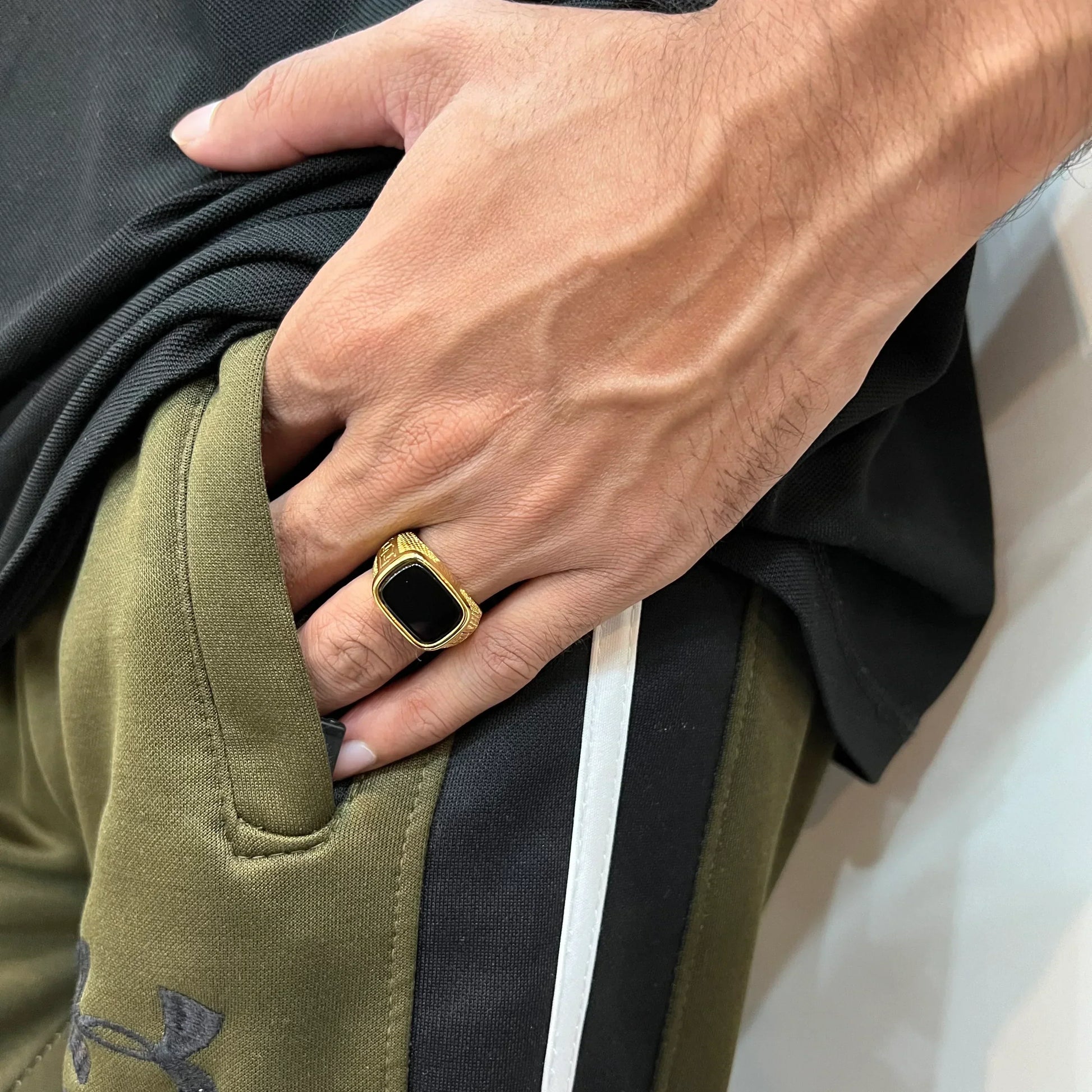 Golden Swiss medusa ring for men worn on hand with black center and gold detailing
