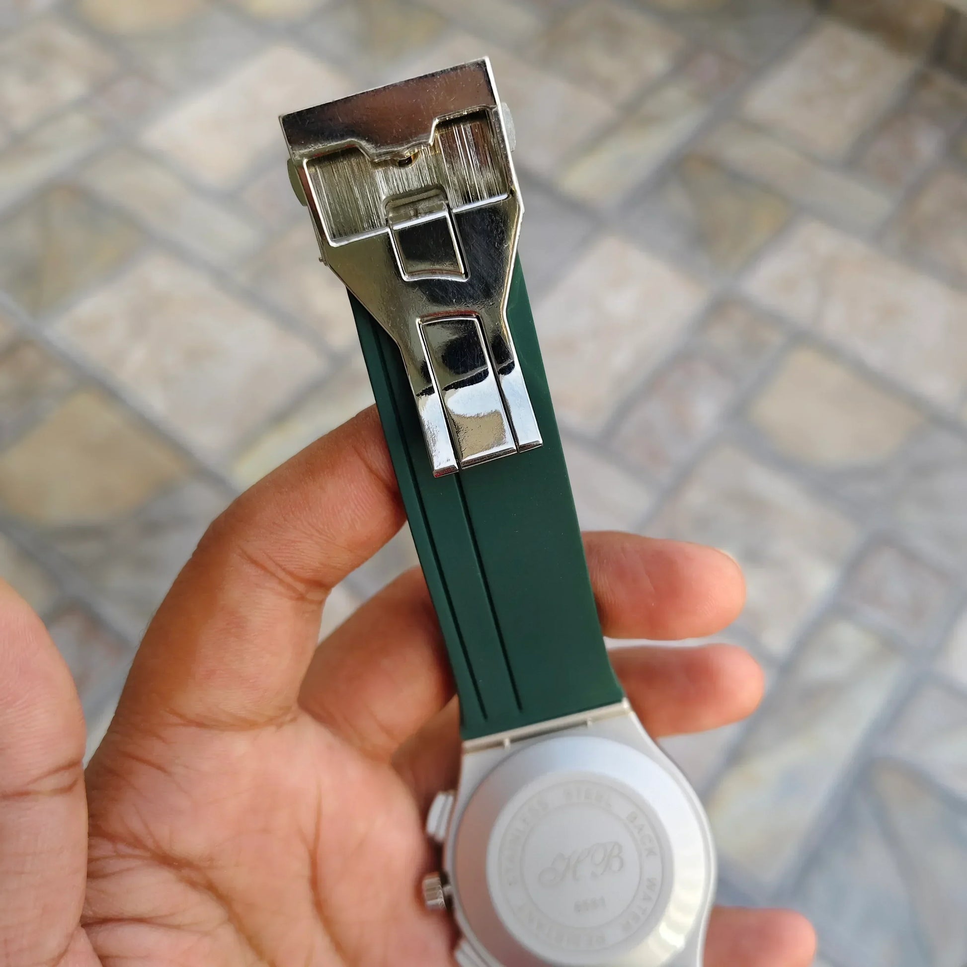 Close-up of Hublot Green Strap Watch showing the green strap and silver clasp held in hand