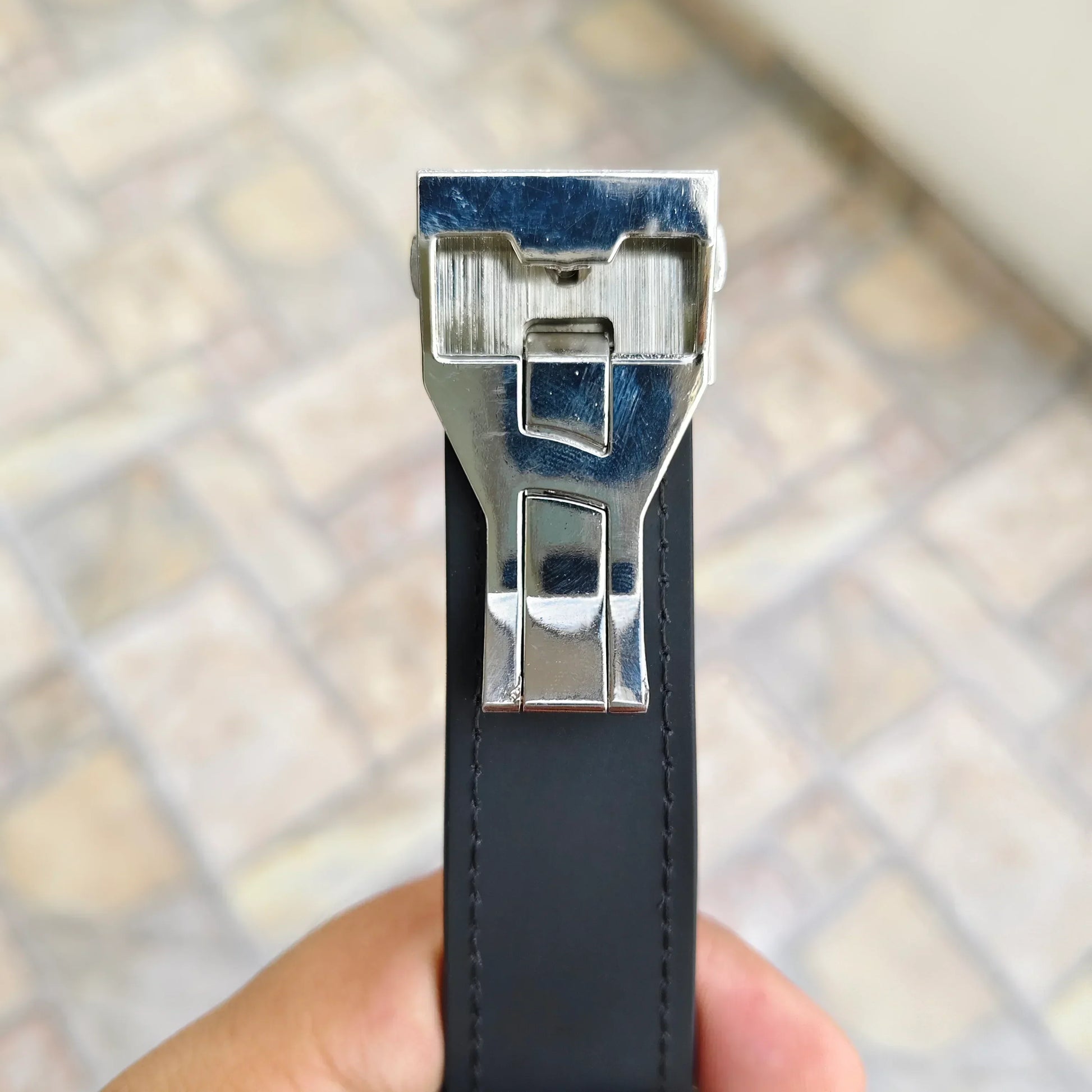 Close-up of a black hub strap watch for men in Pakistan with a silver metal clasp by Lamha