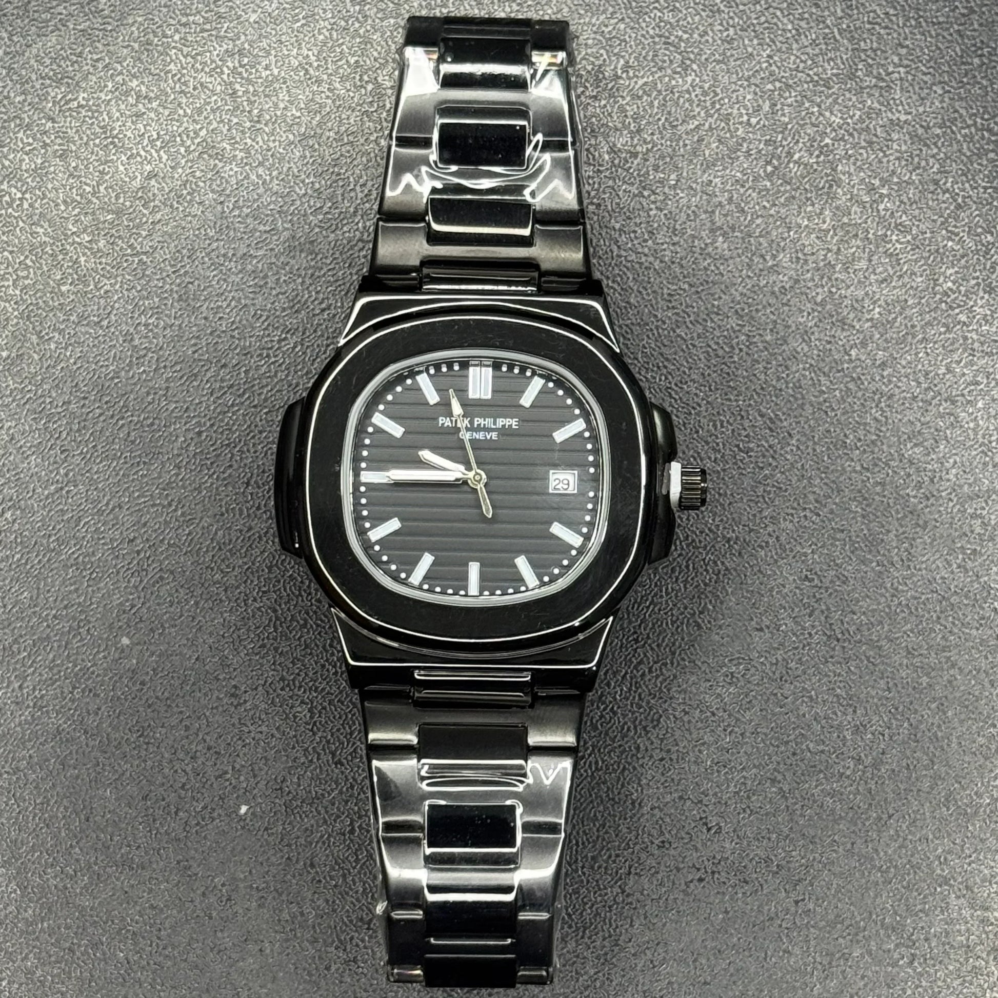 Patek Philippe In Black wristwatch with metal band and date display on textured background