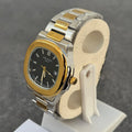 Lamha Patek Philippe Two Tone Golden Black Watch with silver and gold band on display stand
