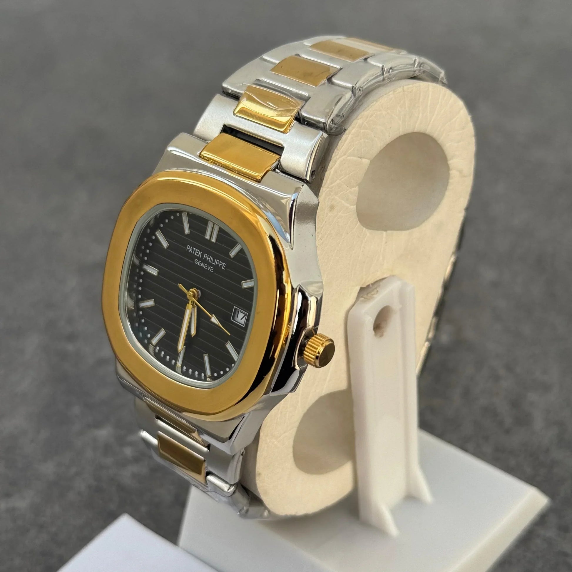 Lamha Patek Philippe Two Tone Golden Black Watch with silver and gold band on display stand