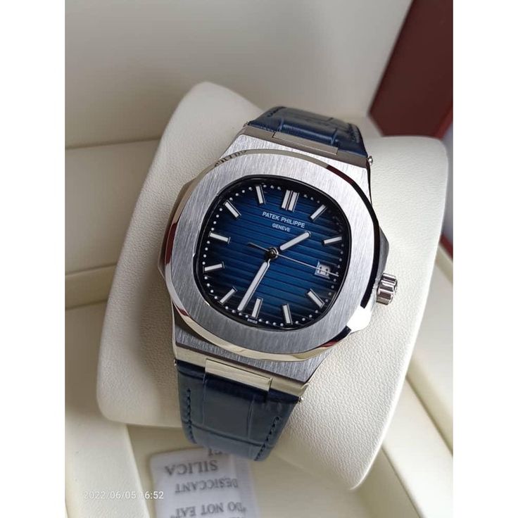 Patek Philippe Watch with blue dial and leather strap displayed on a white cushion