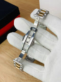 Close-up of silver and gold metal watch bracelet clasp held by gloved hand for patek philippe watch in silver blue