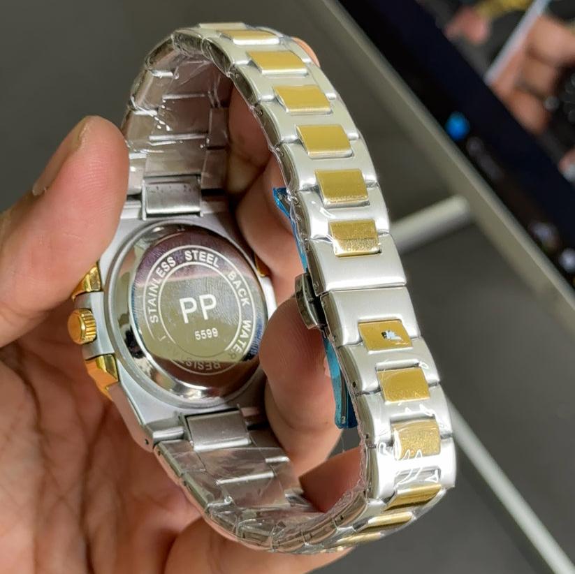 Patek philippe watch in two tone blue color with stainless steel and gold bracelet held in hand