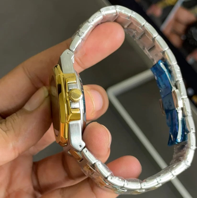 Patek philippe watch in two tone blue color with gold and silver metal band held in hand