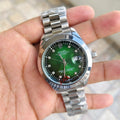 Rolex Date Just Watch for men with green dial and stainless steel bracelet held in hand
