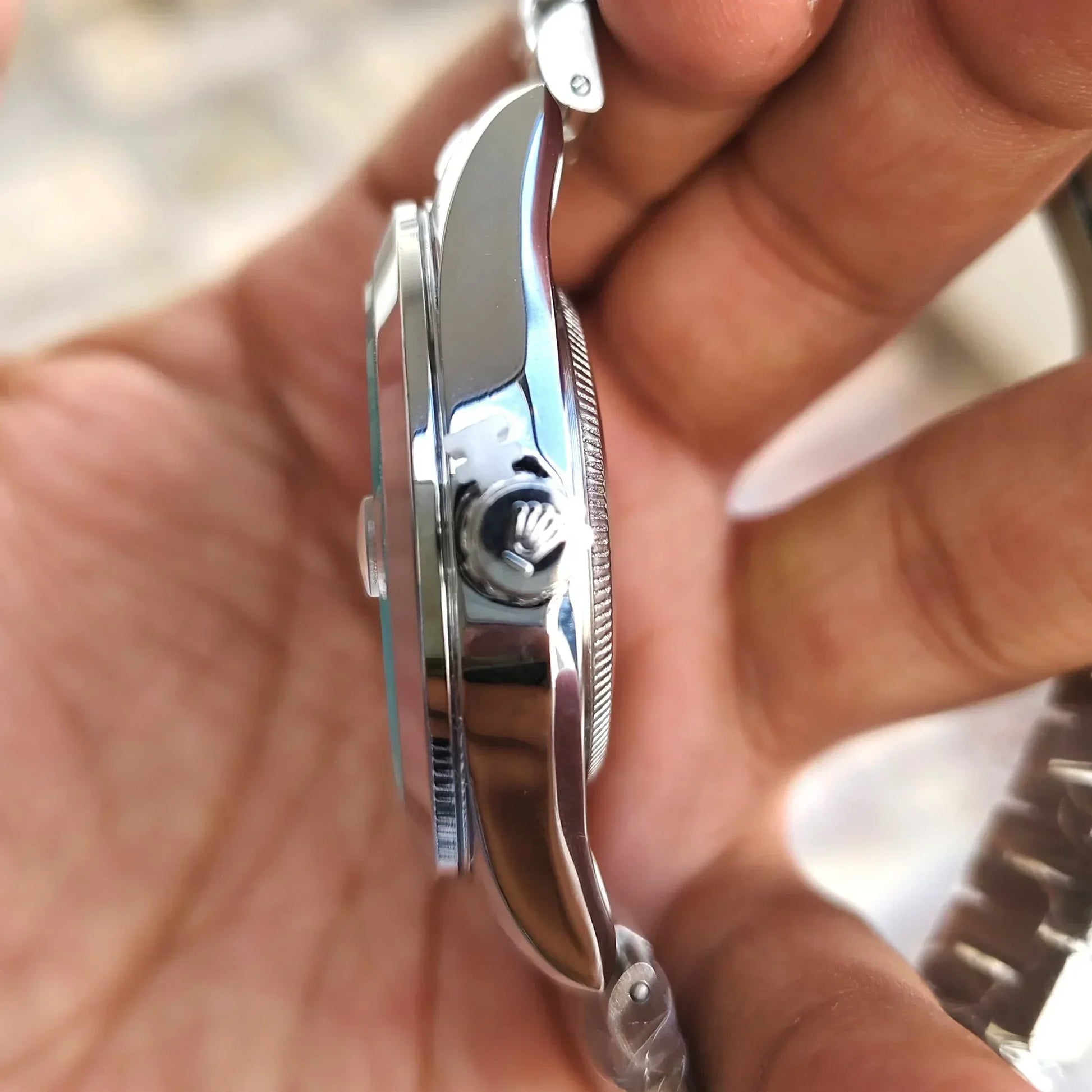 Close-up side view of Rolex Date Just Watch for men showing polished stainless steel case and crown