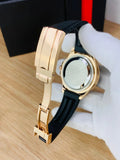Rose gold black Rolex watch for men with black rubber strap held by gloved hand