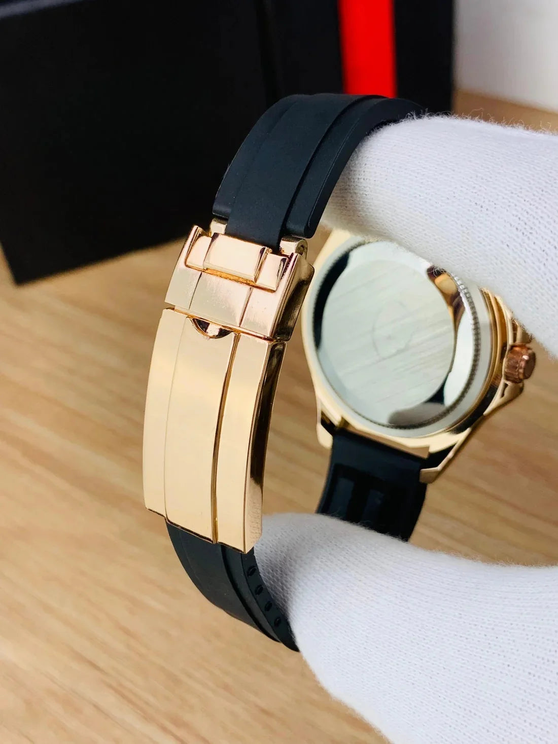 Close-up of rose gold black rolex watch for men with black rubber strap and rose gold clasp