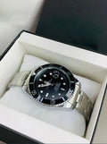 Rolex submariner watch in silver black color with stainless steel band displayed in black and white box