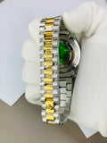 Close up of Rolex watch in stone in two tone gold and silver bracelet held by gloved hand