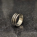 Silver black line ring for men in best design with a polished finish on a dark granite surface