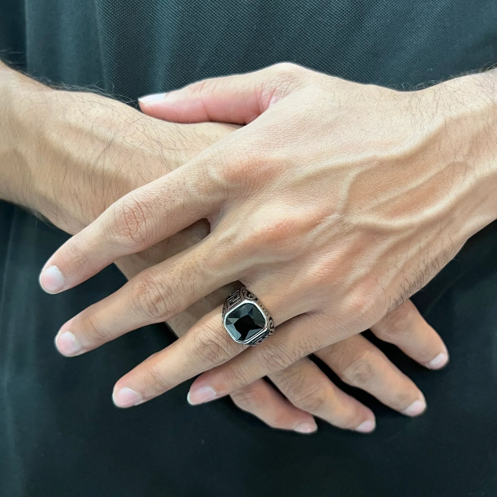 Silver onyx emperor ring for men worn on a hand with detailed silver band and black onyx stone