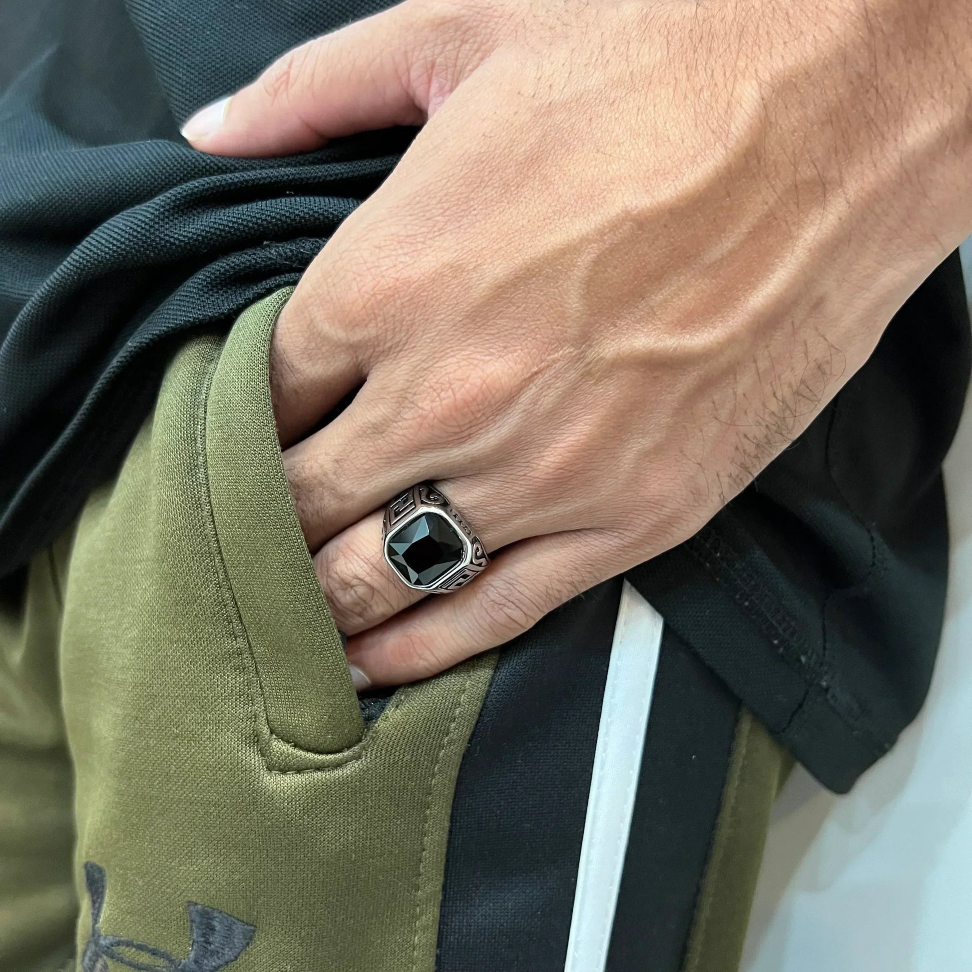 Silver onyx emperor ring for men worn on hand with black and olive green casual clothing