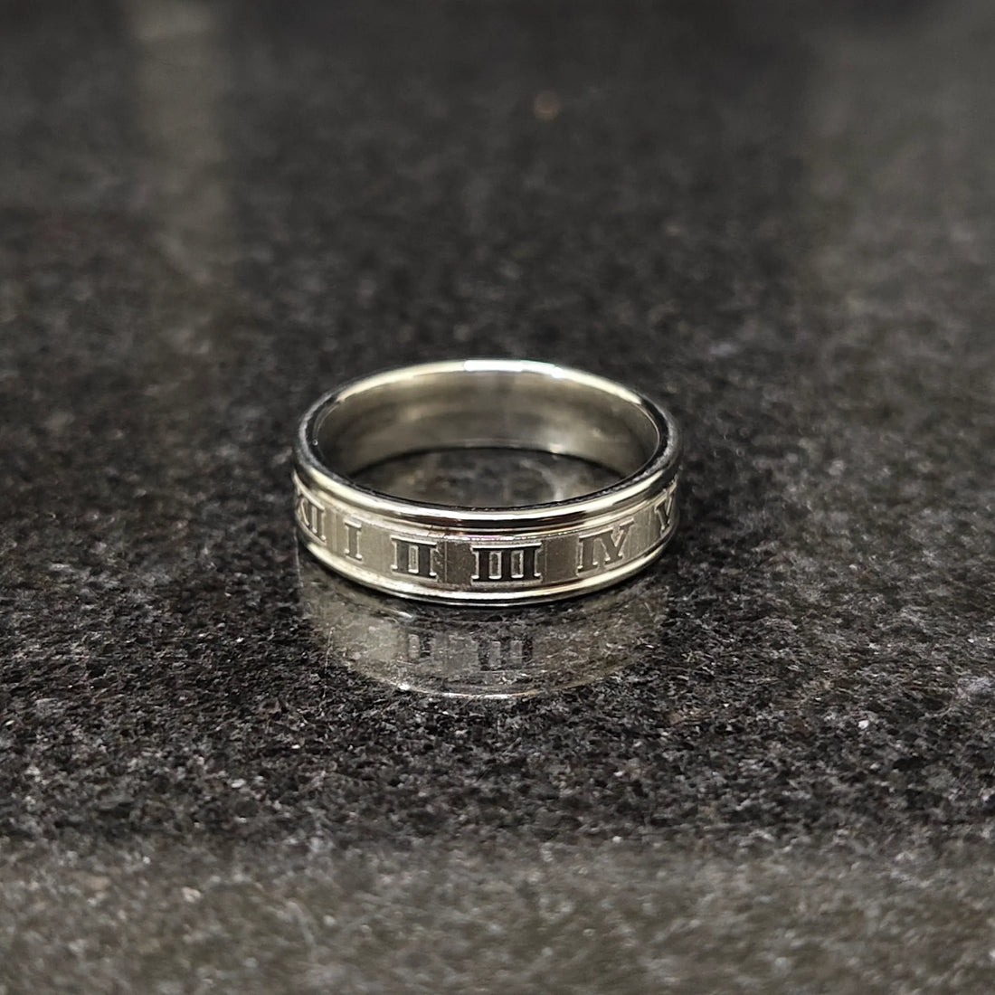 Silver roman ring for men in best design in pakistan displayed on dark granite surface