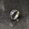 Lamha steal silver ring for men with blue and gold intricate designs on a dark stone surface