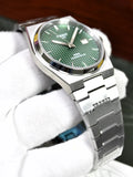 Tissot PRX Chain Watch in Silver Green held by gloved hand showing green textured dial and silver chain bracelet