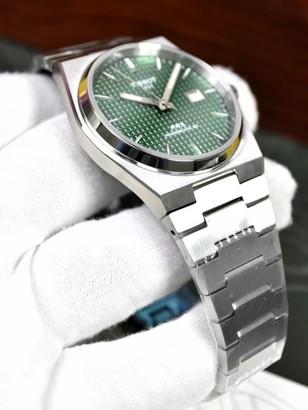 Tissot PRX Chain Watch in Silver Green held by gloved hand showing green textured dial and silver chain bracelet